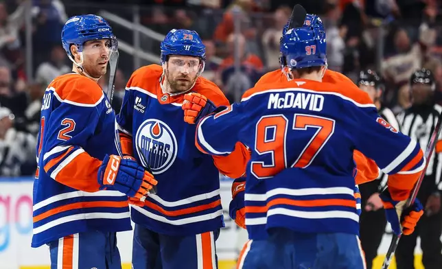 Edmonton Oilers' Evan Bouchard (2), Leon Draisaitl (29) and Connor McDavid (97) celebrate after Draisaitl's goal against the Toronto Maple Leafs during the second period of an NHL hockey game in Edmonton, Alberta, Saturday, Oct. 24, 2026. (Codie McLachlan/The Canadian Press via AP)