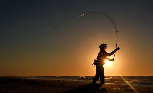 Randy Koeper of West Islip, N.Y., surf casts for striped bass at Hither Hills State Park Beach, Thursday, Oct. 8, 2026, in Montauk, N.Y. (AP Photo/Robert F. Bukaty)