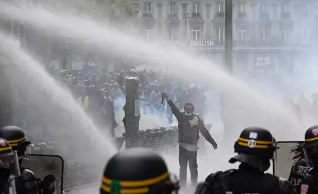 Protesters face police during a demonstration against rising living costs, joining students' grievances, in Paris, Saturday, Oct. 17, 2026. (AP Photo/Emma Da Silva)