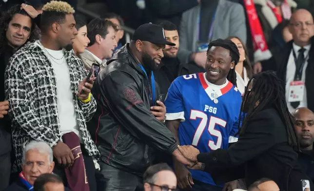 New Orleans Saints players on the stand ahead of the Champions League opening phase soccer match between Paris Saint-Germain and FC Barcelona in Paris, Tuesday, Oct. 20, 2026. (AP Photo/Thibault Camus)