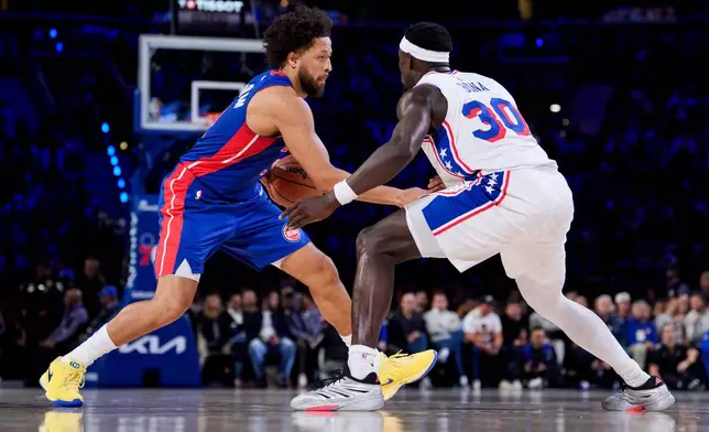 Detroit Pistons' Cade Cunningham, left, makes his move against Philadelphia 76ers' Adem Bona, right, during the first half of an NBA basketball game, Sunday, Oct. 25, 2026, in Philadelphia. (AP Photo/Chris Szagola)