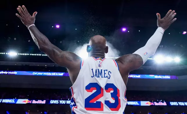 Philadelphia 76ers' LeBron James tosses the chalk in the air ahead of the first half of an NBA basketball game against the Detroit Pistons, Sunday, Oct. 25, 2026, in Philadelphia. (AP Photo/Chris Szagola)