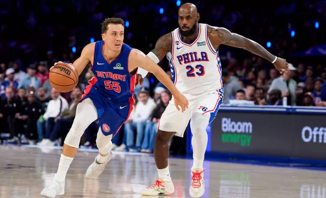 Detroit Pistons' Duncan Robinson, left, drives to the basket against Philadelphia 76ers' LeBron James, right, during the first half of an NBA basketball game, Sunday, Oct. 25, 2026, in Philadelphia. (AP Photo/Chris Szagola)