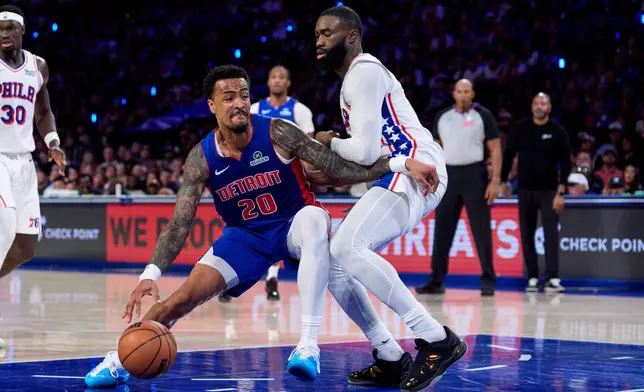 Detroit Pistons' John Collins, left, makes his move against Philadelphia 76ers' Jaylen Brown, right, during the first half of an NBA basketball game, Sunday, Oct. 25, 2026, in Philadelphia. (AP Photo/Chris Szagola)