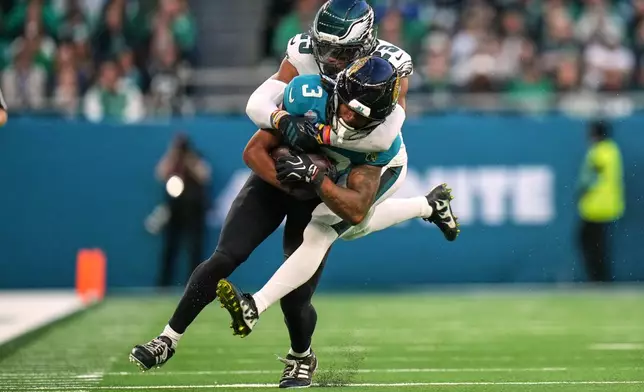 Jacksonville Jaguars wide receiver Jakobi Meyers (3) is tackled by Philadelphia Eagles linebacker Zack Baun (53) during an NFL football game in London, Sunday, Oct. 11, 2026. (AP Photo/Alastair Grant)