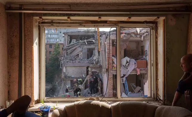 Locals and rescuers clear the rubble of a residential building destroyed in a Russian missile strike on Pryluky, Ukraine, Wednesday, Oct. 7, 2026. (AP Photo/Evgeniy Maloletka)