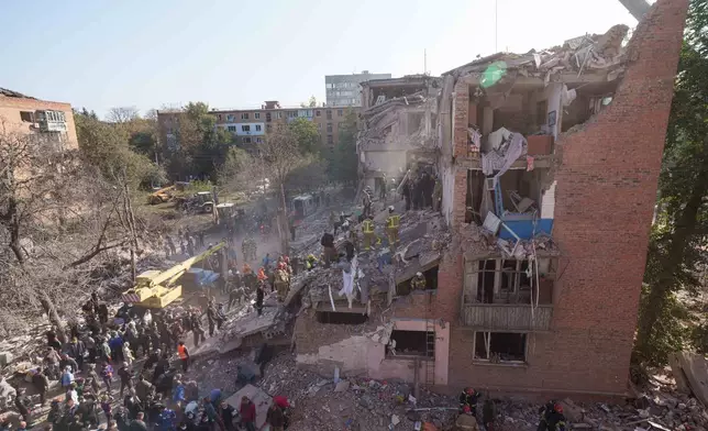 Locals and rescuers clear the rubble of a residential building destroyed in a Russian missile strike on Pryluky, Ukraine, Wednesday, Oct. 7, 2026. (AP Photo/Evgeniy Maloletka)