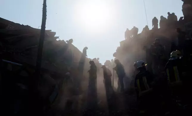 Locals and rescuers clear the rubble of a residential building destroyed in a Russian missile strike on Pryluky, Ukraine, Wednesday, Oct. 7, 2026. (AP Photo/Evgeniy Maloletka)