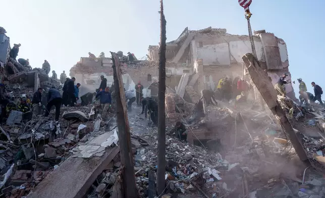 Locals and rescuers clear the rubble of a residential building destroyed in a Russian missile strike on Pryluky, Ukraine, Wednesday, Oct. 7, 2026. (AP Photo/Evgeniy Maloletka)