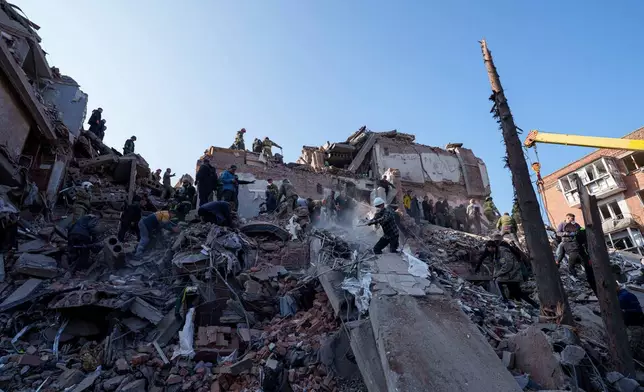 Locals and rescuers clear the rubble of a residential building destroyed in a Russian missile strike on Pryluky, Ukraine, Wednesday, Oct. 7, 2026. (AP Photo/Evgeniy Maloletka)