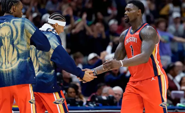 New Orleans Pelicans forward Zion Williamson (1) slaps hands with guard Jeremiah Fears during the first half of an NBA basketball game against the Indiana Pacers in New Orleans, Wednesday, Oct. 21, 2026. (AP Photo/Matthew Hinton)
