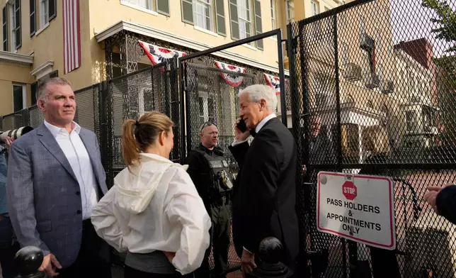 Jaime Dimon, center, CEO of JPMorgan Chase, on his phone as the stopped at a Secret Service Check Point at the White House Complex as he arrives for State Dinner hosted by President Donald Trump for China's President Xi Jinping, Thursday, Sept. 24, 2026, in Washington. (AP Photo/Carolyn Kaster)