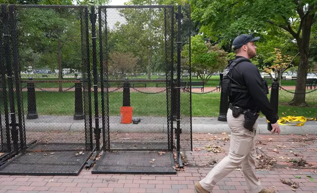 A U.S. Secret Service officer walks past a section of anti-scaling fencing near the White House, Monday, Sept. 28, 2026, in Washington. (AP Photo/Alex Brandon)
