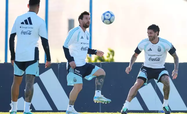 Argentina's Lionel Messi, center, trains for his final game with the national team, an international friendly soccer match against Benin, with teammate Rodrigo De Paul, right, in Buenos Aires, Argentina, Monday, Oct. 5, 2026. (AP Photo/Gustavo Garello)