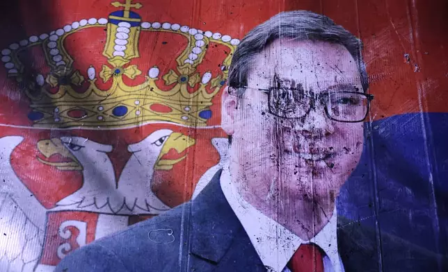 A defaced poster of Aleksandar Vucic, leader of the right-wing Serbian Progressive Party (SNS), lies on the pavement outside the National Assembly, after he conceded defeat in the parliamentary election in Belgrade, Serbia, Sunday, Oct. 25, 2026. (AP Photo/Armin Durgut)