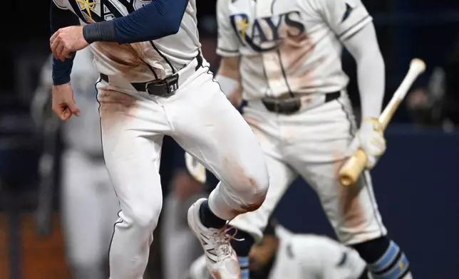 Tampa Bay Rays' Jonny DeLuca, left, celebrates after scoring on a two-run single by Richie Palacios during the fifth inning in Game 2 of an American League Division Series baseball game against the New York Yankees Monday, Oct. 5, 2026, in St. Petersburg, Fla. (AP Photo/Phelan Ebenhack)