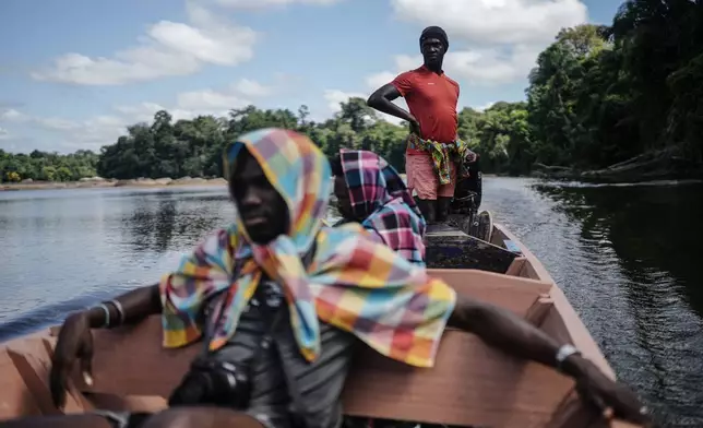 A boat transports local people on the Suriname River near Nieuw Aurora, Suriname, Monday, Sept. 28, 2026. (AP Photo/Ivan Valencia)