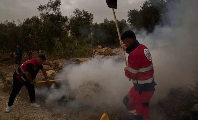 Palestinians extinguish a small fire after Israeli forces fired tear gas following a settler attack during the olives harvest in the West Bank village of Abu Falah, Friday, Oct. 16, 2026. (AP Photo/Leo Correa)