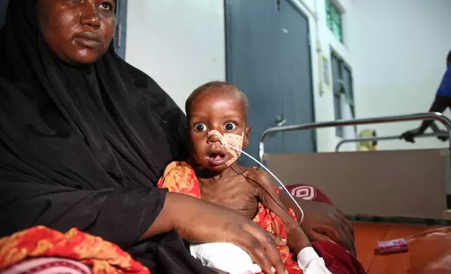 Khadija Hilowle holds her son Abdi Shafi, who is suffering from malnutrition, in Kimanyo general hospital in Kismayo, Somalia, Tuesday, Sept. 22, 2026. (AP Photo/Farah Abdi Warsameh)