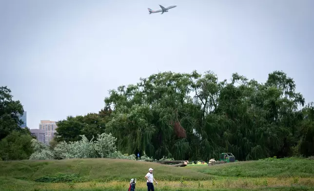 A golfer pauses near trees recently cut down by the National Park Service at East Potomac Golf Links, Saturday, Oct. 10, 2026, in Washington. (AP Photo/Nathan Howard)