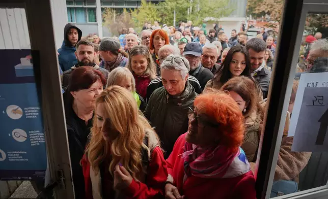 People enter a polling station that just opened its doors to cast their votes in a parliamentary election in Novi Sad, Serbia, Sunday, Oct. 25, 2026. (AP Photo/Armin Durgut)