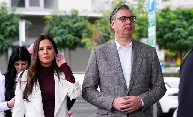 Aleksandar Vucic, leader of the right-wing Serbian Progressive Party (SNS), waits along with his wife Tamara to vote in a parliamentary election in Belgrade, Serbia, Sunday, Oct. 25, 2026. (AP Photo/Petr David Josek)