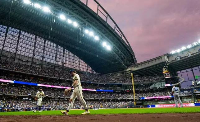 Milwaukee Brewers players return to the dugout during the sixth inning of Game 2 of baseball's National League Championship Series between the Milwaukee Brewers and the Los Angeles Dodgers, Monday, Oct. 12, 2026, in Milwaukee. (AP Photo/Ashley Landis)