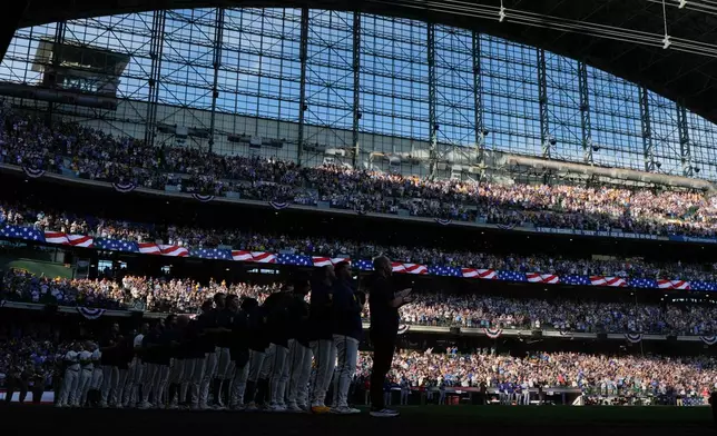The Milwaukee Brewers stand for the anthem prior to Game 2 of baseball's National League Championship Series between the Milwaukee Brewers and the Los Angeles Dodgers, Monday, Oct. 12, 2026, in Milwaukee. (AP Photo/Ashley Landis)