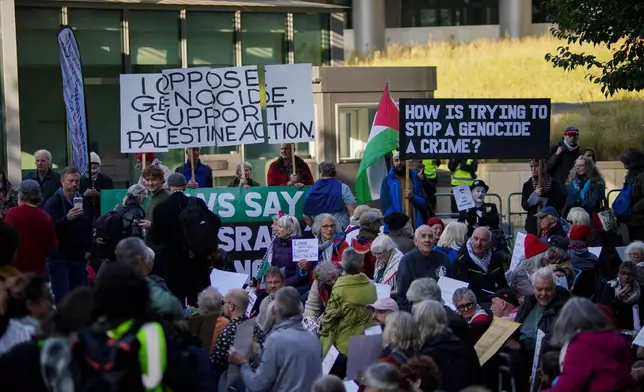 Demonstrators hold placards in support of Palestine Action, outside the US embassy, in London, Saturday, Oct. 31, 2026. (AP Photo/Alberto Pezzali)