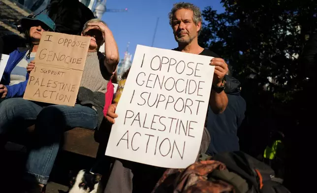 A protester holds a placard during a demonstration in support of Palestine Action, outside the US embassy, in London, Saturday, Oct. 31, 2026. (AP Photo/Alberto Pezzali)