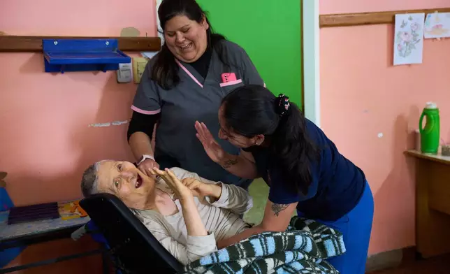 Resident Jose Ferreira laughs with instructor Julia Casas during a workshop at Pequeño Cottolengo Don Orione, a home for people with disabilities that Pope Leo XIV is scheduled to visit in November, in Buenos Aires, Argentina, Thursday, Oct. 29, 2026. (AP Photo/Rodrigo Abd)