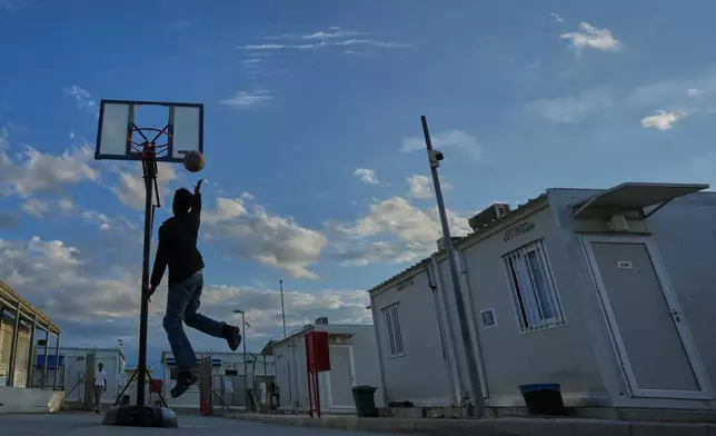 A man plays basketball at the Pournara migrant reception centre in Kokkinotrimithia area, on the outskirts of Nicosia, Cyprus, on Friday, Oct. 30, 2026. (AP Photo/Petros Karadjias)