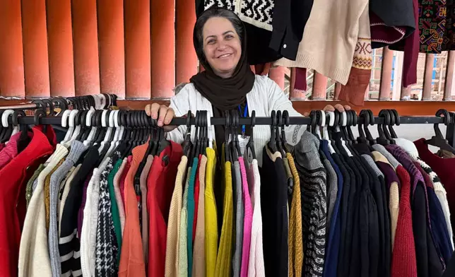 A vendor smiles while standing at her stall at Jomeh Bazaar, or Friday Market, in Tehran, Iran, Friday, Oct. 30, 2026. (AP Photo/Vahid Salemi)