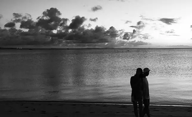 Gary貼出與一女子在海邊散步的照片。（網上圖片）