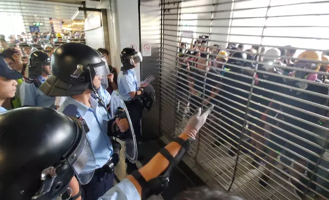 防暴警員協助港鐵職員關閉鐵閘。