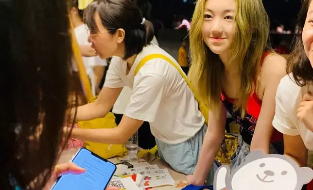 染上一頭金髮的李嫣笑面迎人，落力義賣籌款。