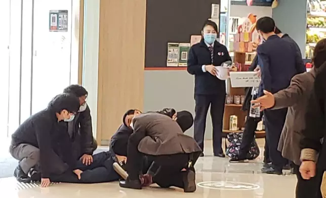 男子被職員制服在地。讀者提供