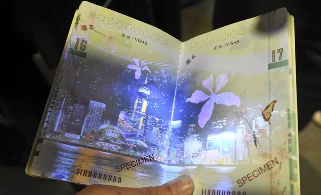 新一代特區護照在視像光譜對比儀的紫外光燈照射下，顯示整個維港夜景及紫荊花圖樣。