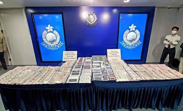 警方展示檢獲的現金及手提電話等證物。