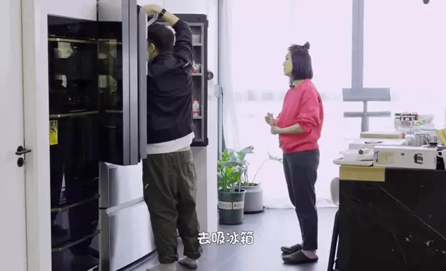 丁子高用吸塵機清潔雪櫃。（網上圖片）