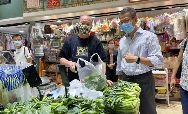 陳茂波到訪街市時與市民和商戶交流。