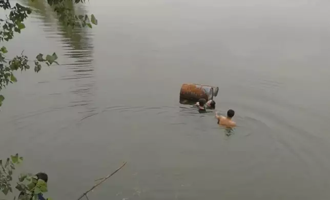 越野車墮入水庫，母子逃離車廂後抱著油桶等待救援。網上圖片
