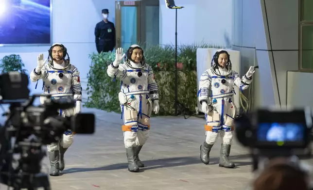 3名太空人英姿勃勃，向現場支持者揮手。新華社圖片