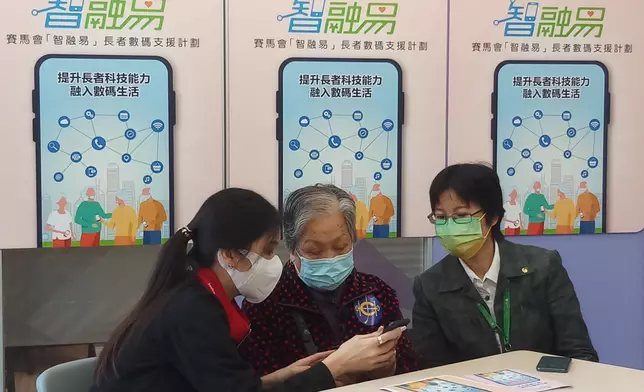 許婆婆（中）獲贈智能手機後，隨即學習如何使用。