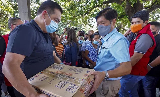 菲律賓總統小馬可斯視察災情，派發救濟包給災民。AP