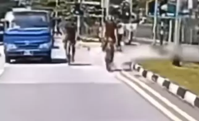 該單車手伸手敲擊該貨車的倒後鏡。影片截圖