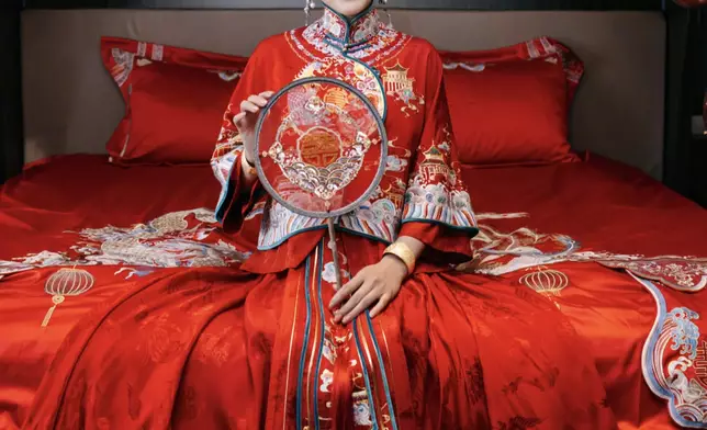 徐夢桃穿上中式大紅色結婚禮服，手持喜扇。
