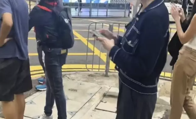 有網民在中環街頭偶遇關之琳，等待過馬路的她一直低頭玩電話。
