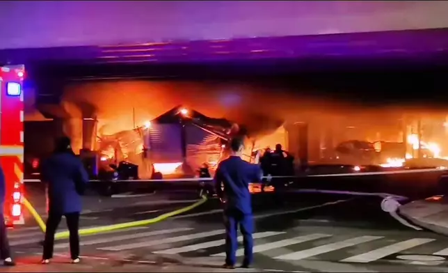 當地消防正撲滅橋下起火的建築物。