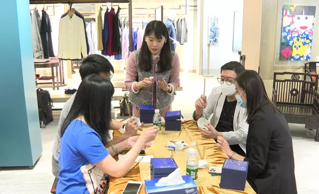 孫德娜在現場指導參觀者作畫。